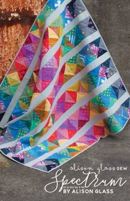 Spectrum Modern Quilt Pattern by Alison Glass shows a bright and colorful strippy quilt that features bright and vivid colors in a modern quilt design.
