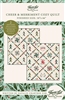 Cover shows a Christmas quilt featuring a quilt panel with seasonal graphics on an on-point set in reds & greens & teals on cream ground.