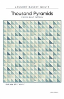 The Thousand Pyramids Quilt Pattern by Laundry Basket Quilts features a large central star created with an outline of the star shape, using narrow strips of color, with all the fabrics being from the Blue Escape Collection.