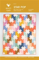 Cream Sawtooth Star set on a brightly covered array of  background colors.