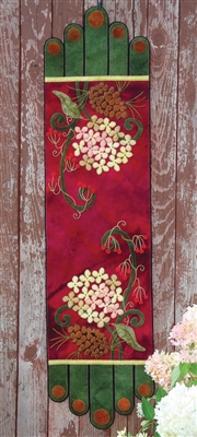 Winter Bouquet Wool Runner Kit features pinecones, berries, and winter blossoms on a rich burgundy Red Ground.  appliqued in buttery soft wool.